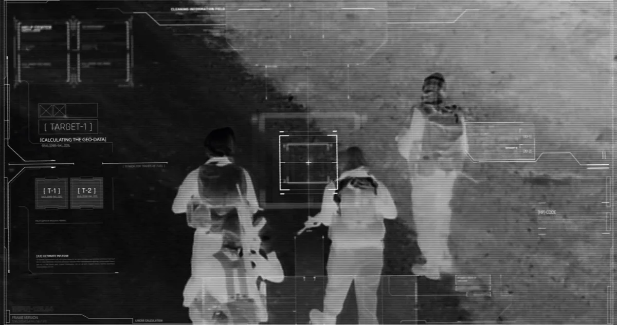 Night-vision targeting view of figures under observation with a heads-up overlay